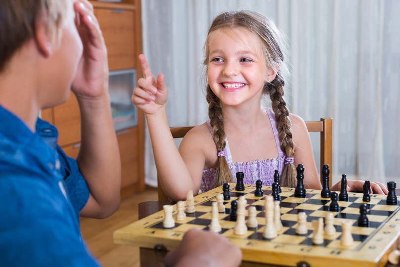 Two children playing wooden chess